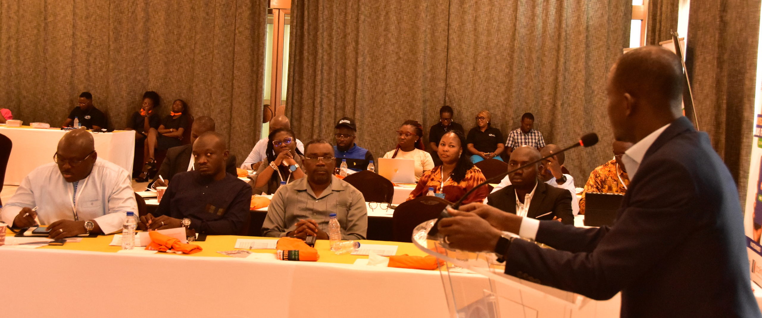 man in black suit pointing in blue screen on wall