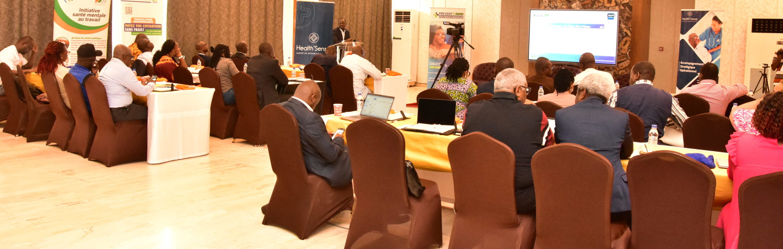 man in black suit pointing in blue screen on wall